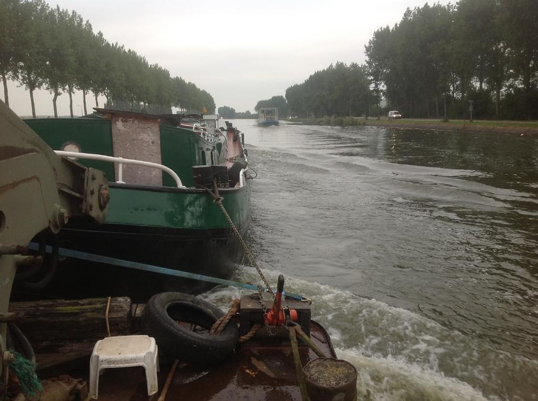 Duwsleepboot van Trionaut sleept een binnenvaartschip door een kanaal